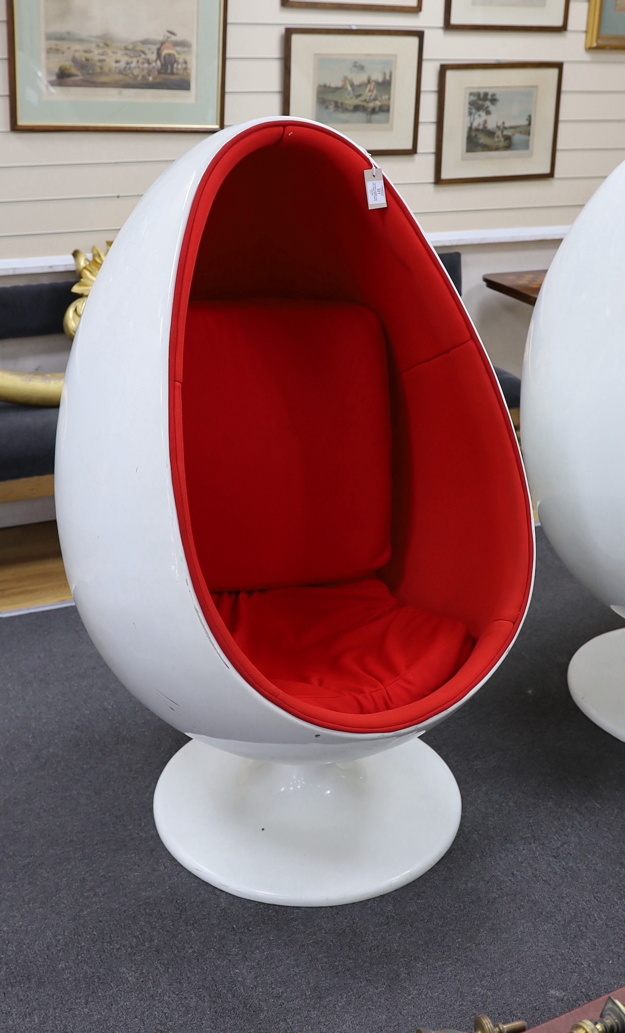 An egg pod chair, in the style of Eero Aarnio, with white plastic shell and rotating base